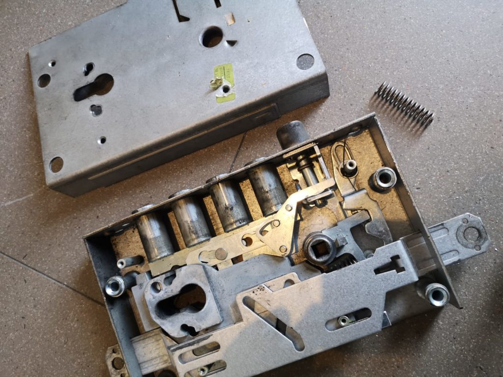 Rozebrany mechanizm zamka drzwiowego podczas naprawy w Nałęcz Clinic w Katowicach